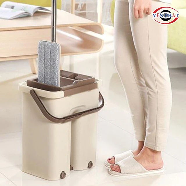 Đưa cây lau nhà vào thùng nước giặt