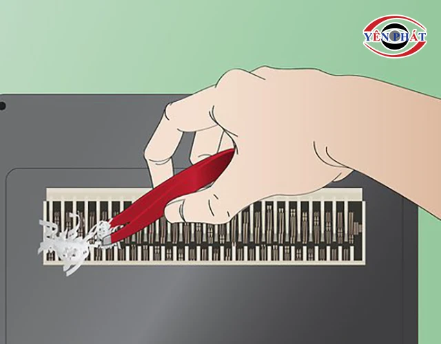 dùng nhíp kéo nhẹ tay để giấy vụn rời khỏi lưỡi dao