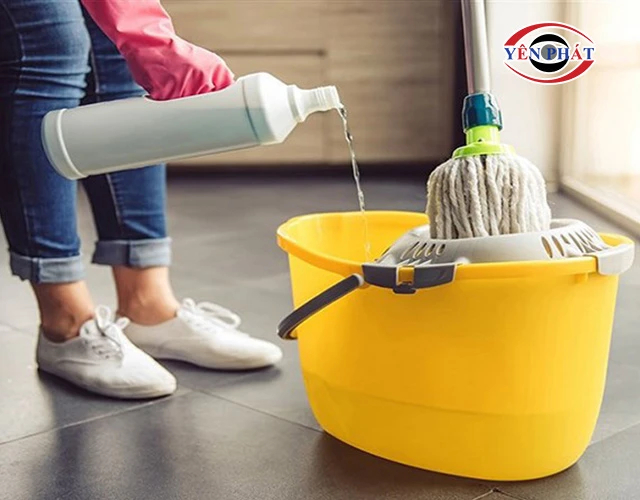 Đổ nước và dung dịch lau vào xô chứa