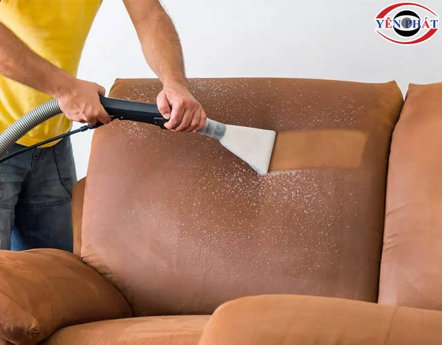 thực hiện vệ sinh ghế sofa bằng máy hút bụi